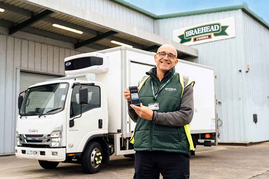 Braehead Foods employee holding a device with the Podfather login screen