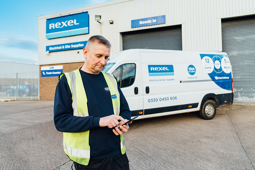 Rexel employee holding device with Podfather app infront of a van