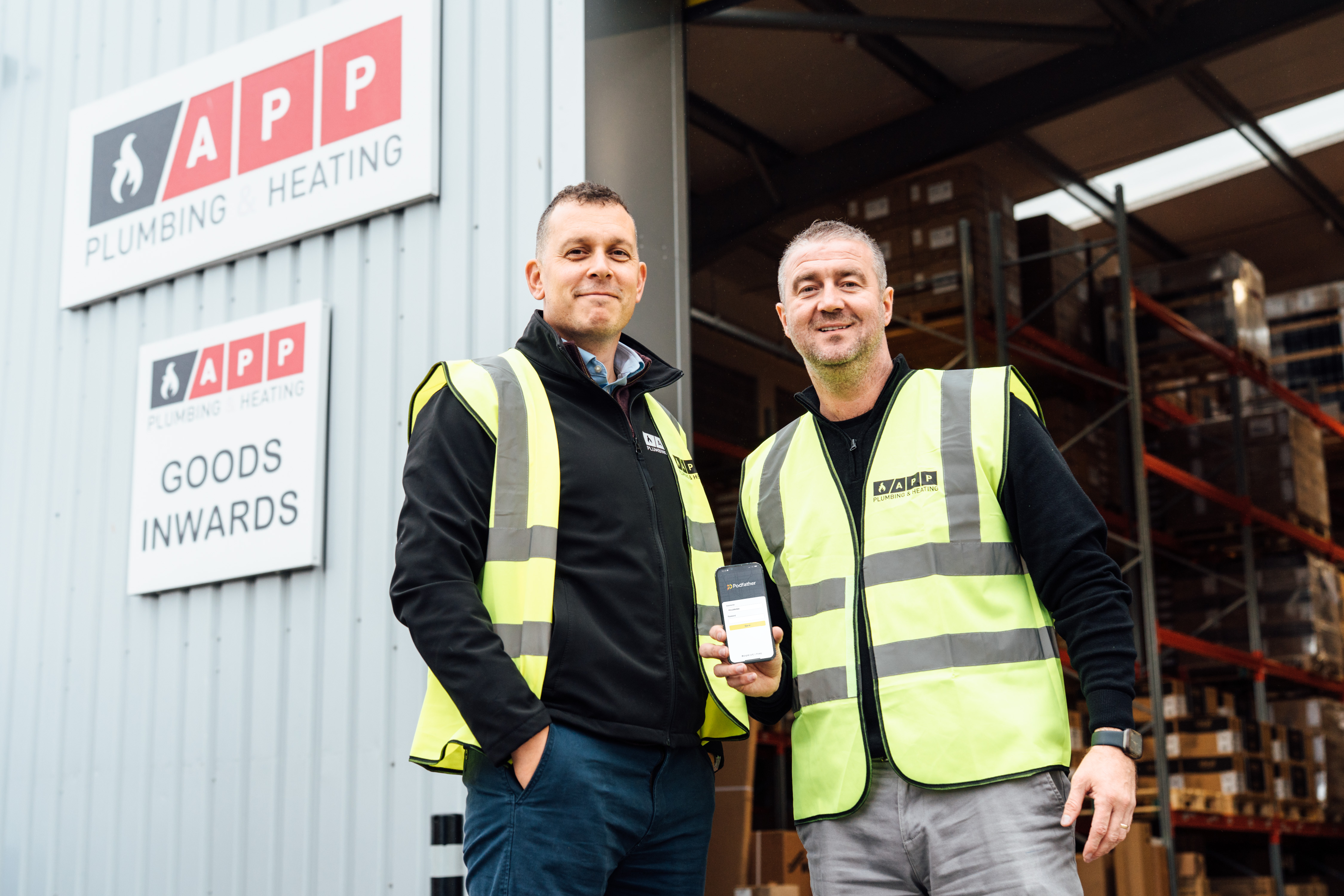 APP Wholesale employees holding a device with Podfather on it