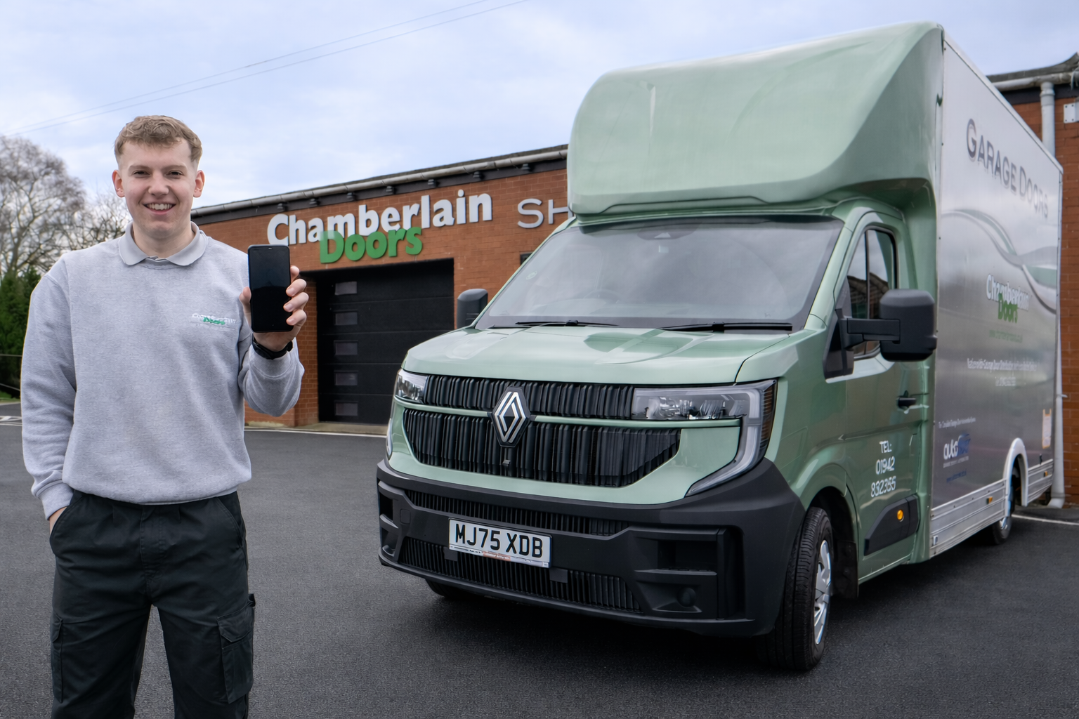 man holding a mobile phone standing in front of a van