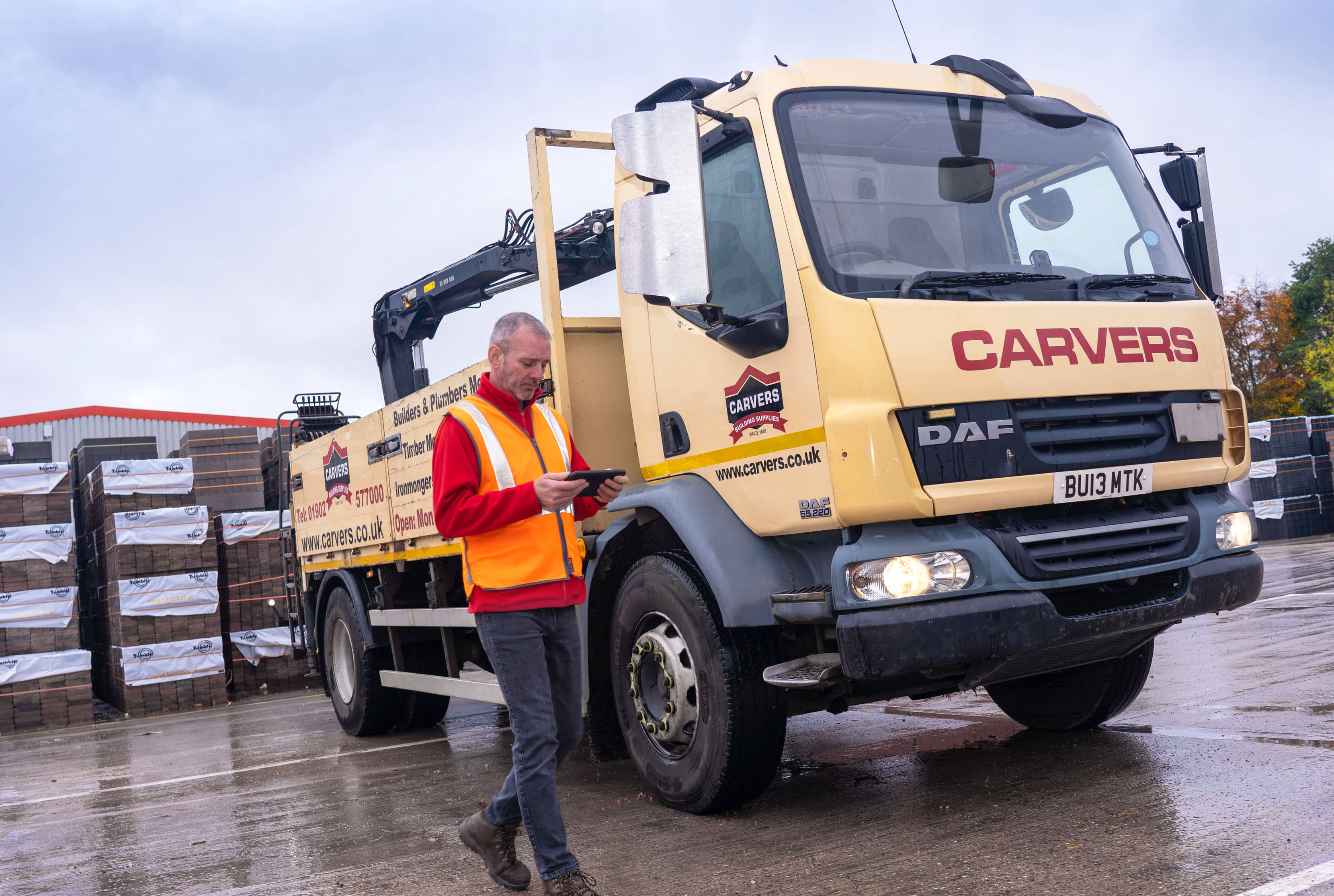Man using mobile device infront of lorry