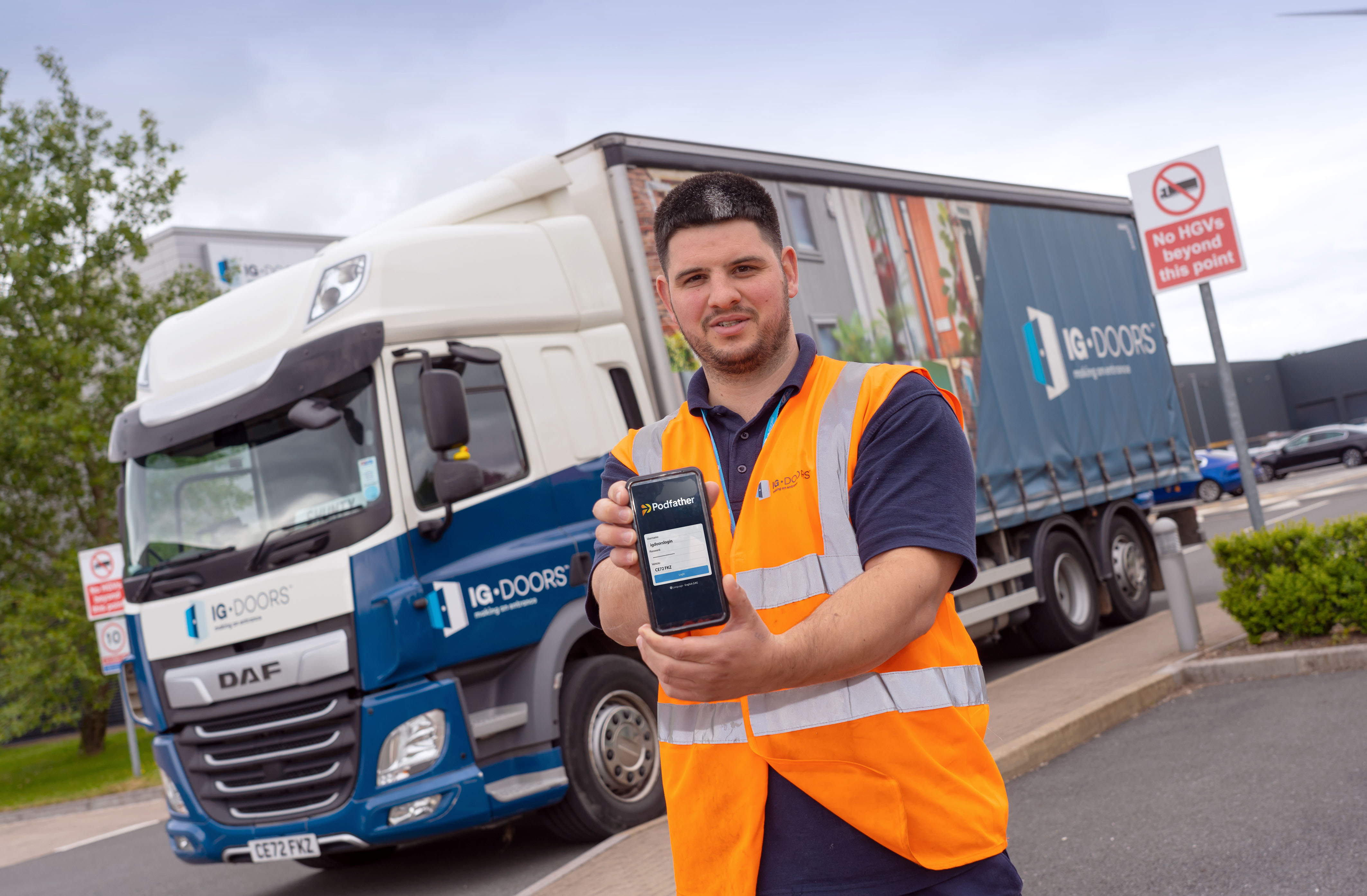 Truck driver holding smartphone showing Podfather app