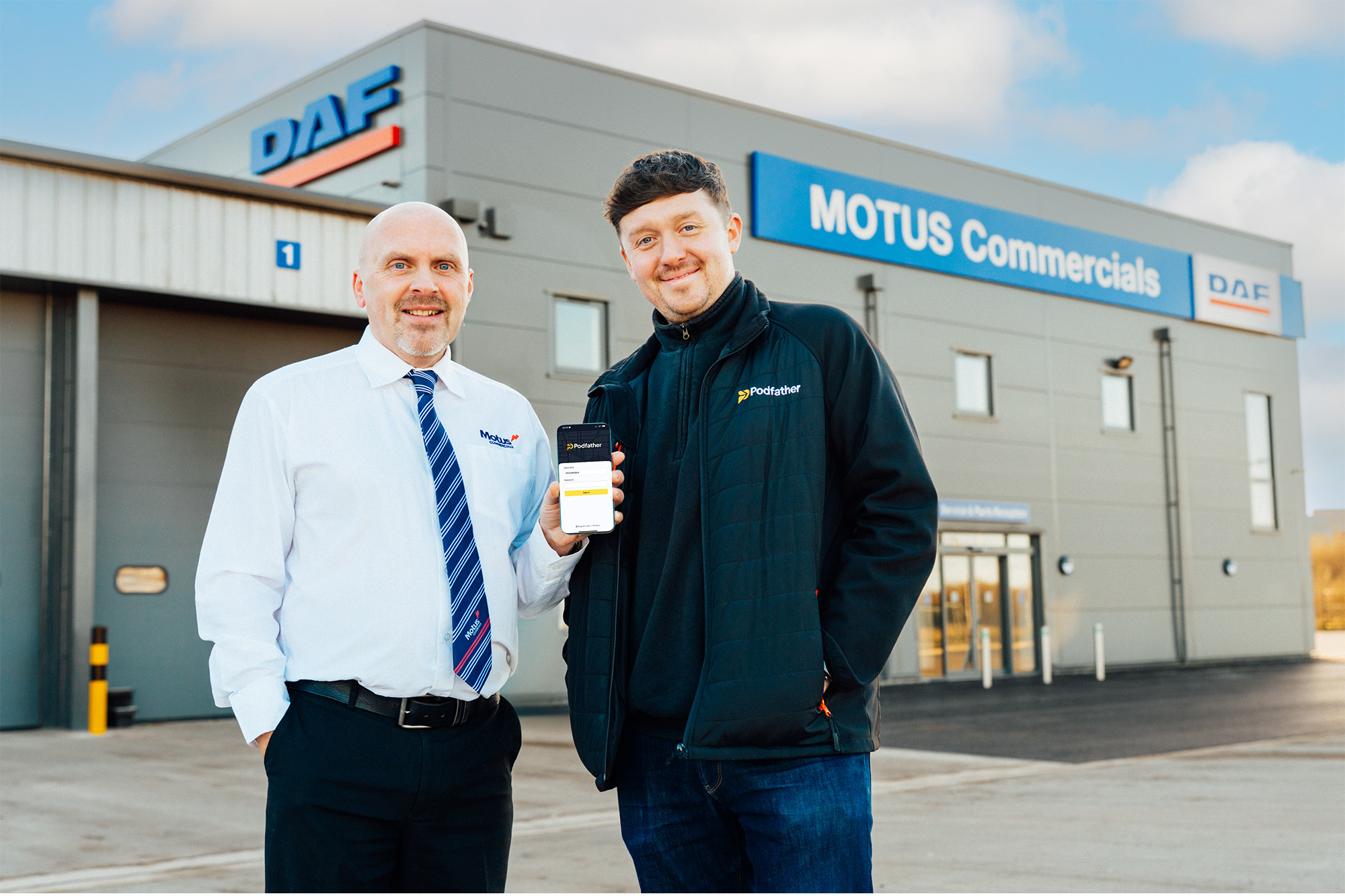 Two men standing in front of the Motus Commercial building