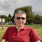 smiling man in a red shirt looking at the camera