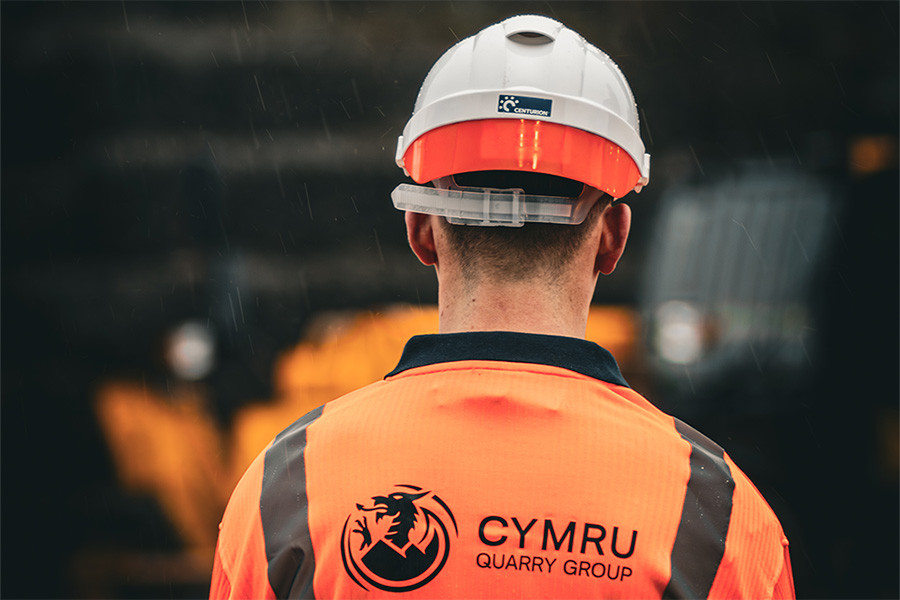 man in an orange high vis top with the words Cymru on the back