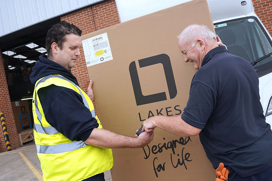 Man in a high vis handing over a parcel to another man who is signing for it on a mobile device