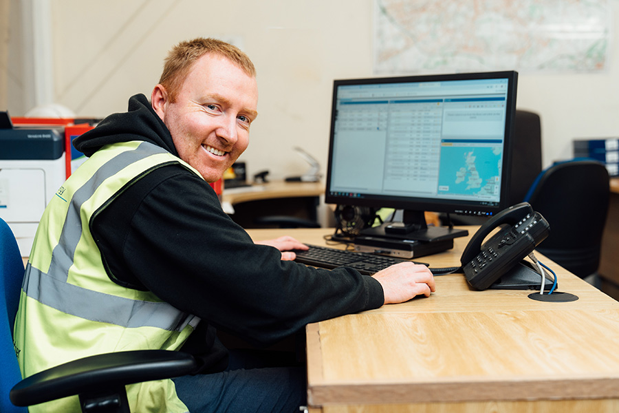smiling man sitting at a computer