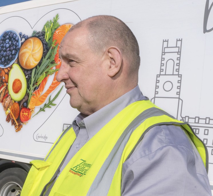 Man in a yellow high vis standing in front of a truck