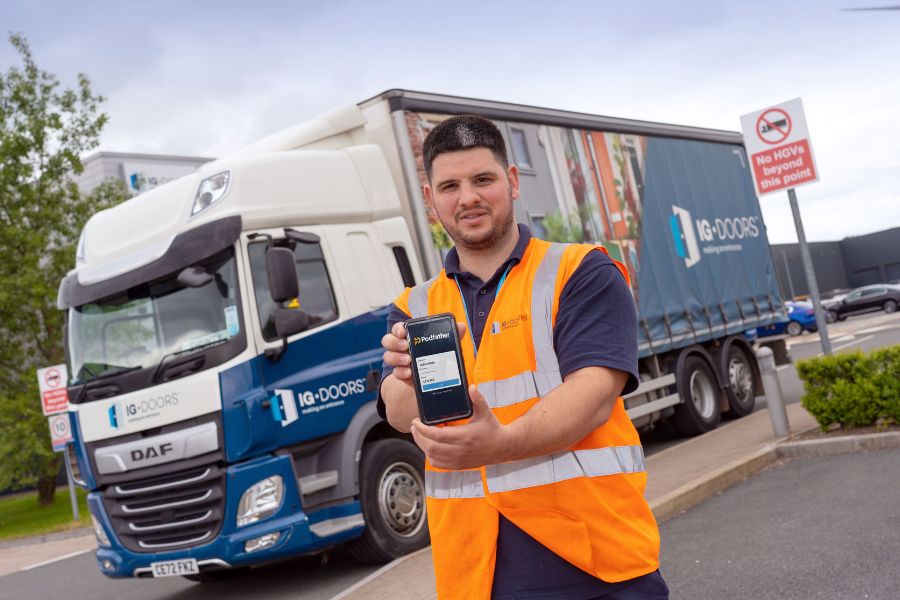 Truck driver holding smartphone showing Podfather app